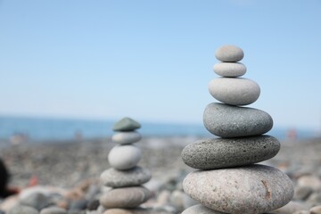Fototapeta na wymiar Stack of stones on beach against blurred background, closeup. Space for text