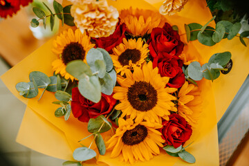Bunch of sunflowers in tin bucket with roses