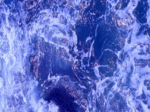 Stormy ocean waves, shiny blue water .