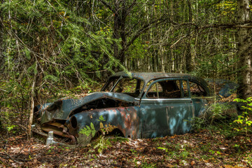 Old rusted abandoned car in the woods