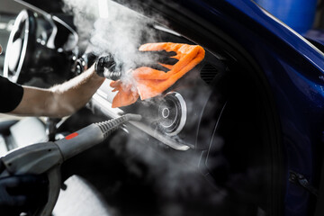 Steam cleaning of car air system. Worker in auto cleaning service clean car inside. Car interior...
