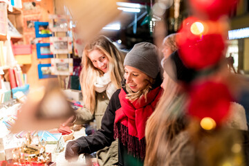 Fototapeta na wymiar Happy young women shopping at Christmas market in Innsbruck