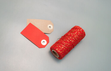  red ribbon and name tags for wrapping New Year's gifts. cotton red ribbon with golden inserts. place for text, christmas atmosphere, new year, gifts, family, holiday