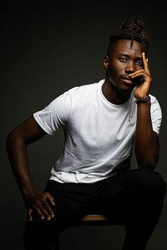 studio portrait with dark background of man with white shirt