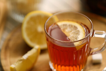 Glass mug of aromatic tea with lemon on board, closeup. Space for text