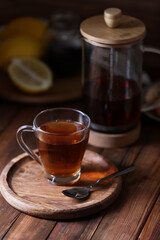 Glass cup with delicious tea on wooden table