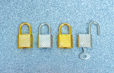Shiny padlocks and key on sparkling background