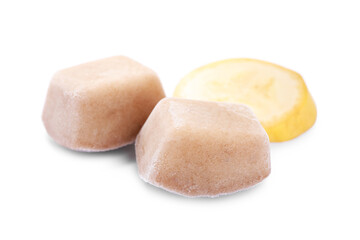 Frozen banana puree cubes and fruit on white background