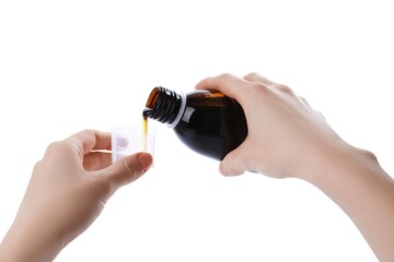 Woman pouring syrup into measuring cup from bottle isolated on white, closeup. Cough and cold...