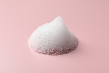Drop of fluffy soap foam on pink background