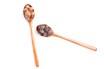 Close up of two types of couverture chocolate. Chocolate callets in wooden spoon isolated on white.