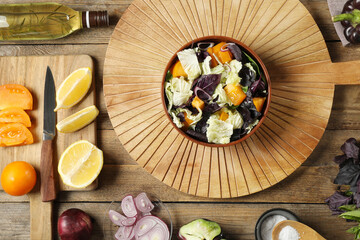 Delicious salad with Chinese cabbage, tomato and basil served on wooden table, flat lay