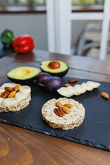 Vegan rice bread for breakfast with avocado and plums. Healthy Eating.