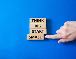 Think big start small symbol. Concept words Think big start small on wooden blocks. Beautiful blue...