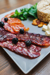 Slice of dried meat with vegetables. delicious snacks made of ham, prosciutto. Meat plate