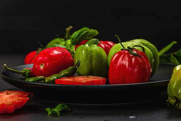 Green and red ribbed tomatoes, American or Florentine variety. Ripe vegetables, fresh bay leaves