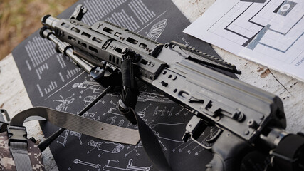 Kalashnikov machine gun on a soft “game” mat with the image of a Kalashnikov assault rifle