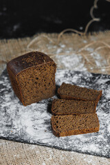 Slices of whole grain rye fresh bread on a dark background close up. Fresh home-baked sourdough bread