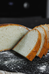 Slices of whole grain rye fresh bread on a dark background close up. Fresh home-baked sourdough bread
