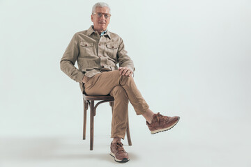 old casual man relaxing on a wooden chair
