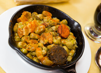 Popular Catalan style beans cooked with sliced blood sausage, chorizo, fried bacon and spices