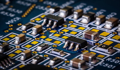 Close-up to blue printed circuit board with electronic components.	