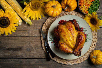 Happy Thanksgiving holiday background. Roasted whole chicken or turkey with autumn vegetables for...