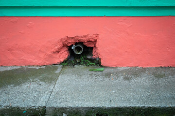 Pipe in a Hole in the Red Painted Wall
