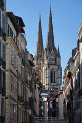 Views between buildings of the Sainte-Marie Cathedral of Bayonne during a sunny day.