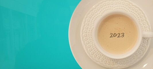 coffee with white cup with blue background written 2023, happy new year 2023