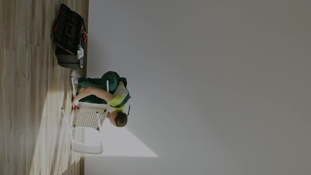Female is assembling a chair. Vertical video