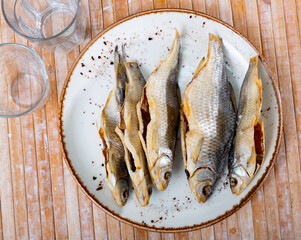 Dried roaches served on wooden table. Bunch of kippers.