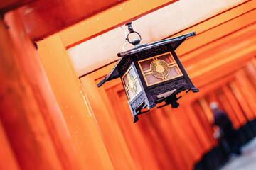 Red Tori Gate at Fushimi Inari Shrine in Kyoto, Japan. Selective focus on traditional japanese writing.