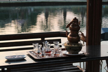 A tiny tea urn in a pergola near a lake. Tea session