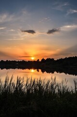 Wonderful, colorful summer landscape. Sunset in the beautiful sky over the lake.