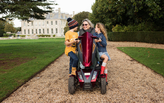 disabled grandma on a mobility scooter with her grandchildren outdoors