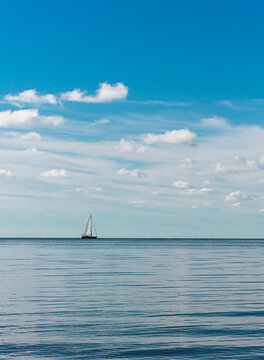 Sailboat sailing on a calm lake on a beautiful day in Ontario, Canada.