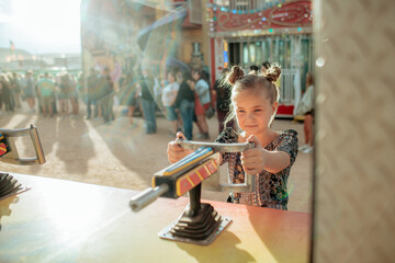 Young girl playing a carnival game on sunny day