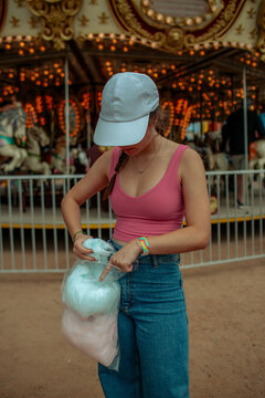 Teen girl opening cotton candy at a carnival