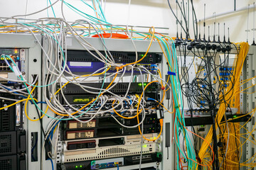 There are many communication cables in the server room of the data center. Small antennas of gsm gateways are installed in the server rack.
