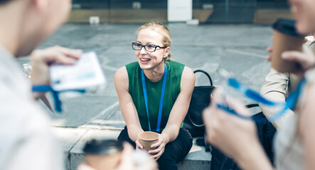 Cheerful colleagues meeting on stairs outdoor for in a quick coffee break. Coffee to go.