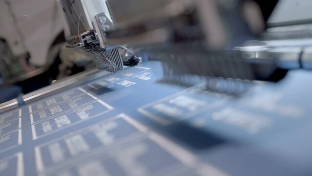 The process of embroidering on fabric with an industrial loom. Macro. Closeup