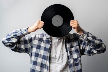 holding a vinyl record disc in front of head