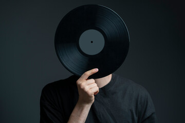holding a vinyl record disc in front of head - obrazy, fototapety, plakaty