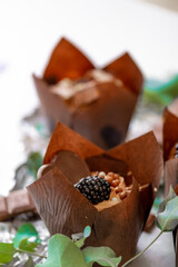 Chocolate dessert. Chocolate cupcake. muffin with blackberry and eucalyptus leaves on silver foil.Assorted sweet table. Sweets and desserts. Baked goods and desserts