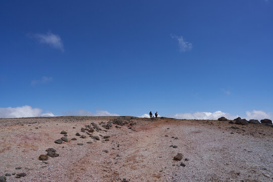 Two climbers walking on a rocky trail from Mt. Kumagadake to Mt. Mamiyadake