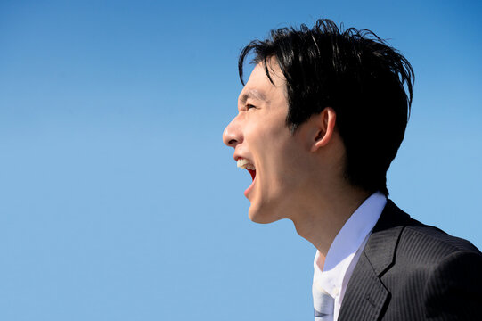 大きな声で呼んだり叫ぶスーツの男性のイメージ