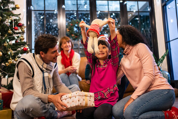 Caucasian family exchanging presents during Christmas party at home. 