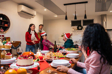 Multi-ethnic big family celebrating Christmas party together in house.