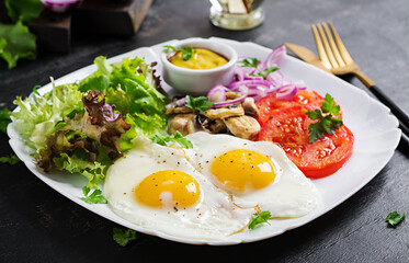 Ketogenic food. Fried eggs, mushrooms and sliced tomatoes. Keto, paleo breakfast.